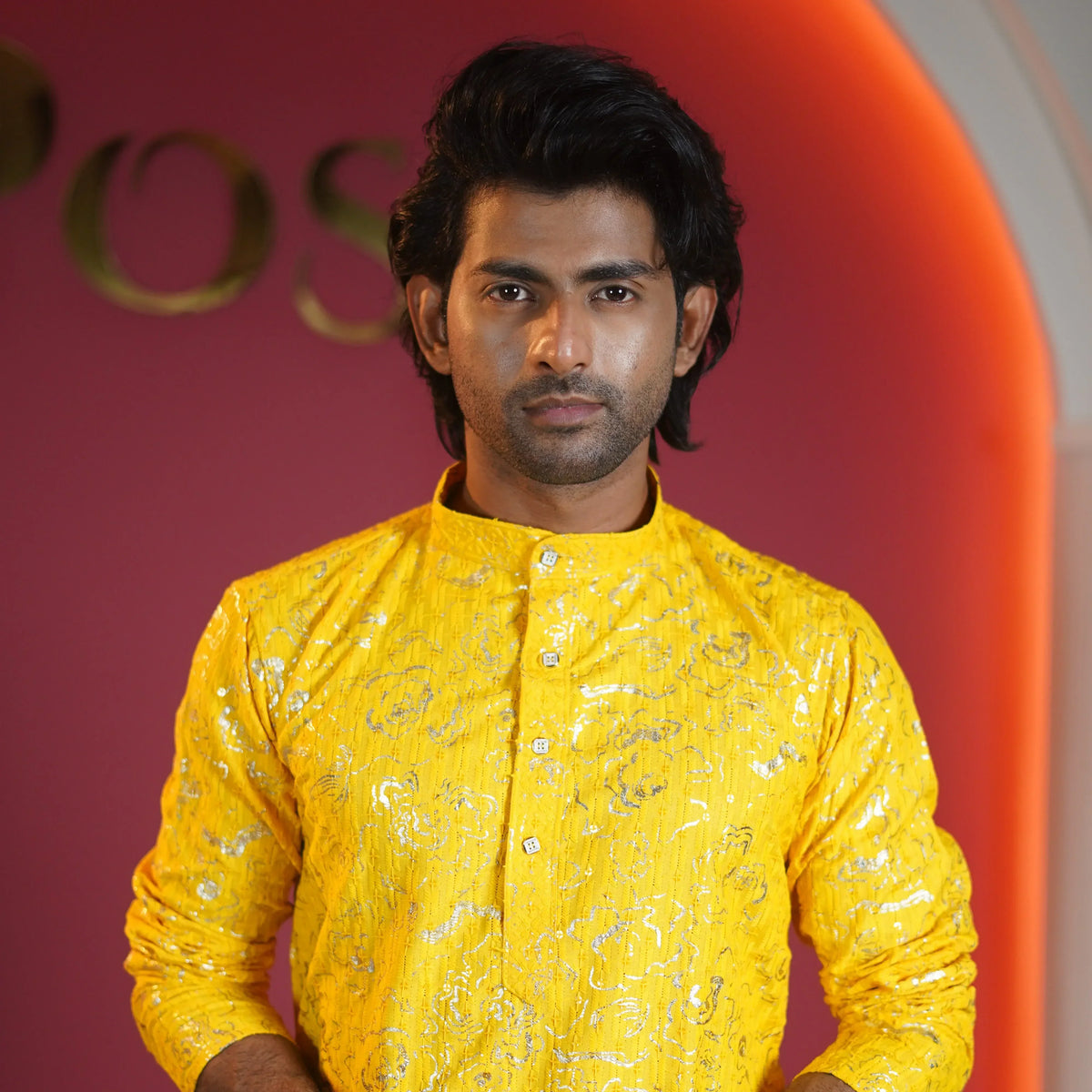 Male model wearing a yellow embroidered kurta in a studio setting with an orange background, showcasing traditional ethnic wear.