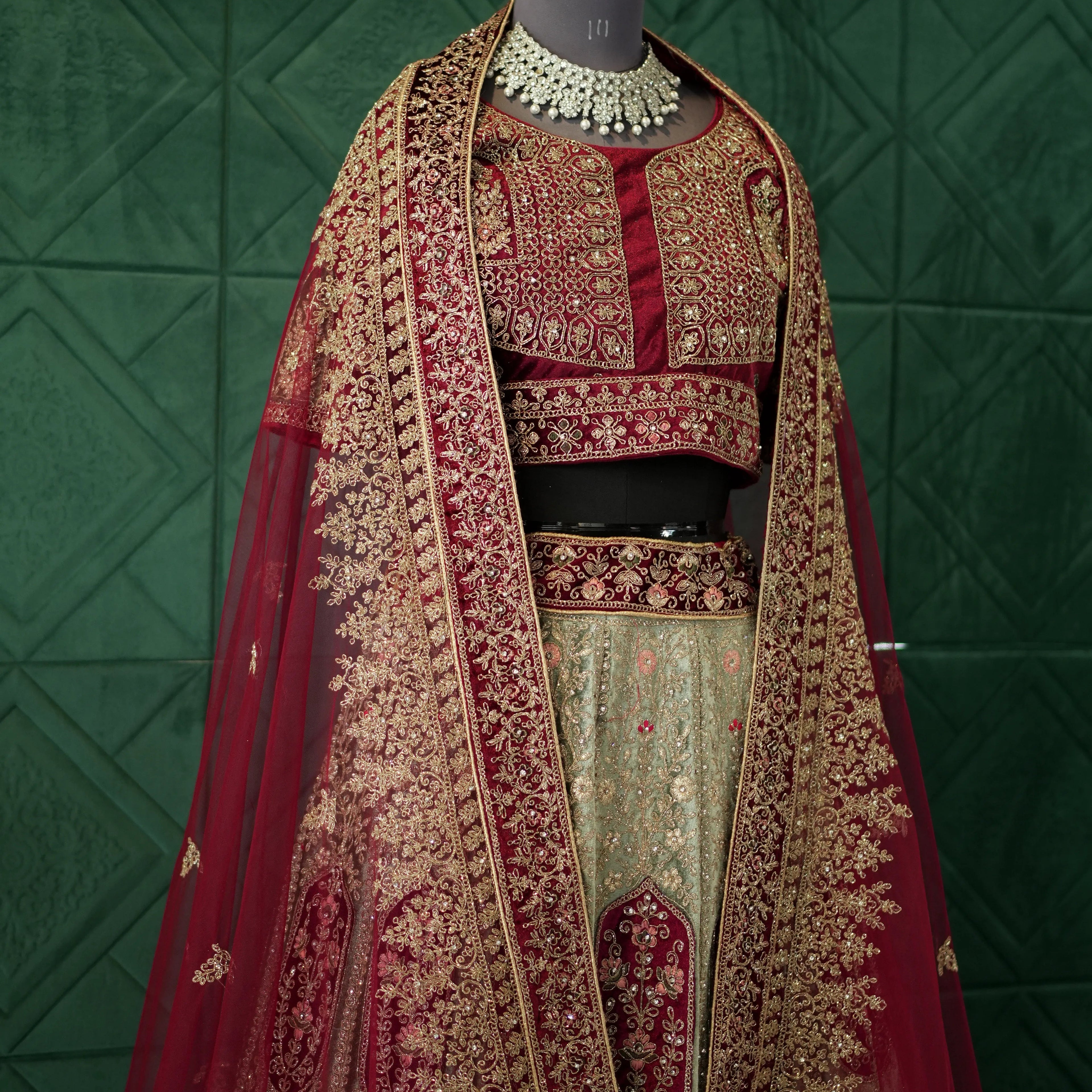 Traditional embroidered outfit on a mannequin against a green tiled wall
