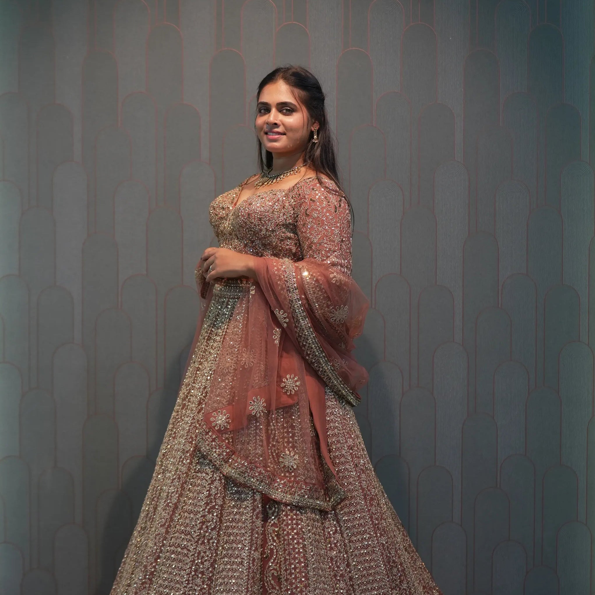women wearing Light Brown Crop Top Lehenga for her wedding and posing for photo 