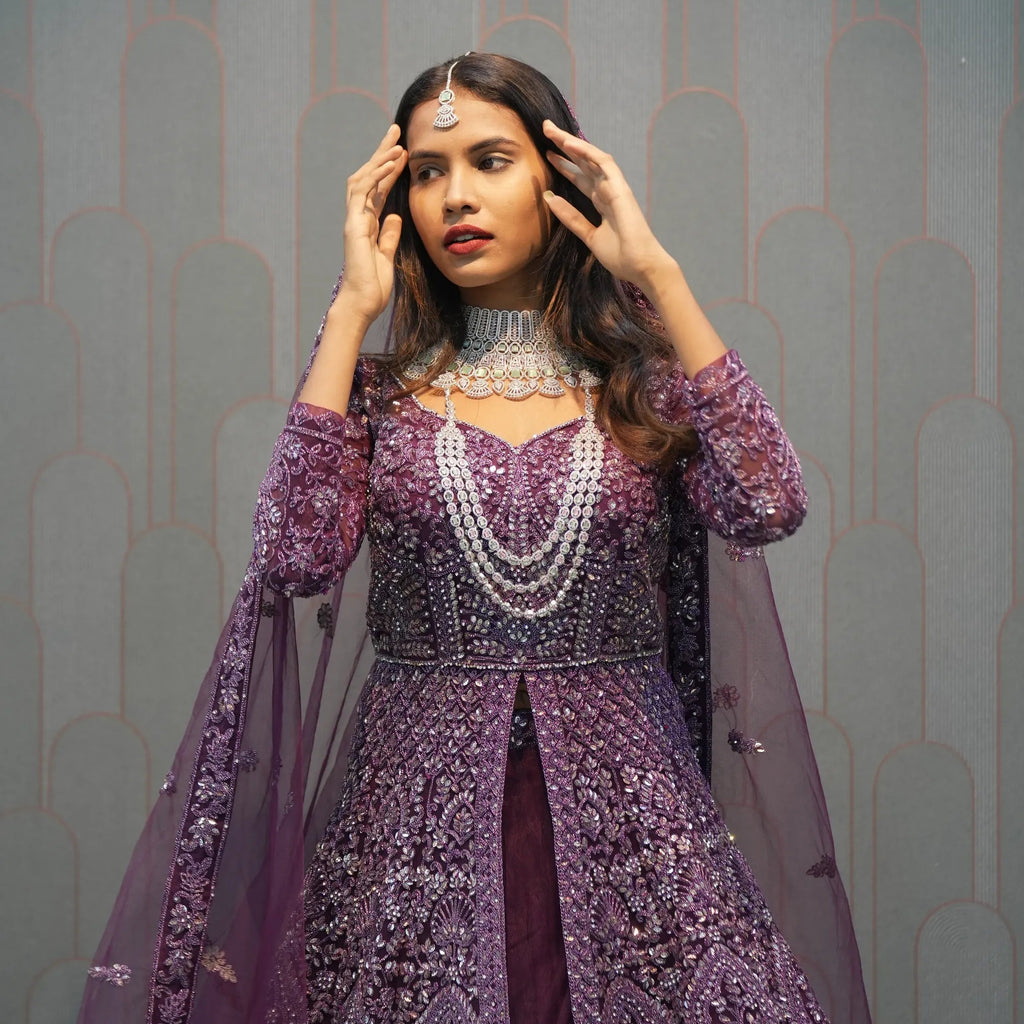 Woman in a purple embroidered outfit with 'POSH' branding in the background