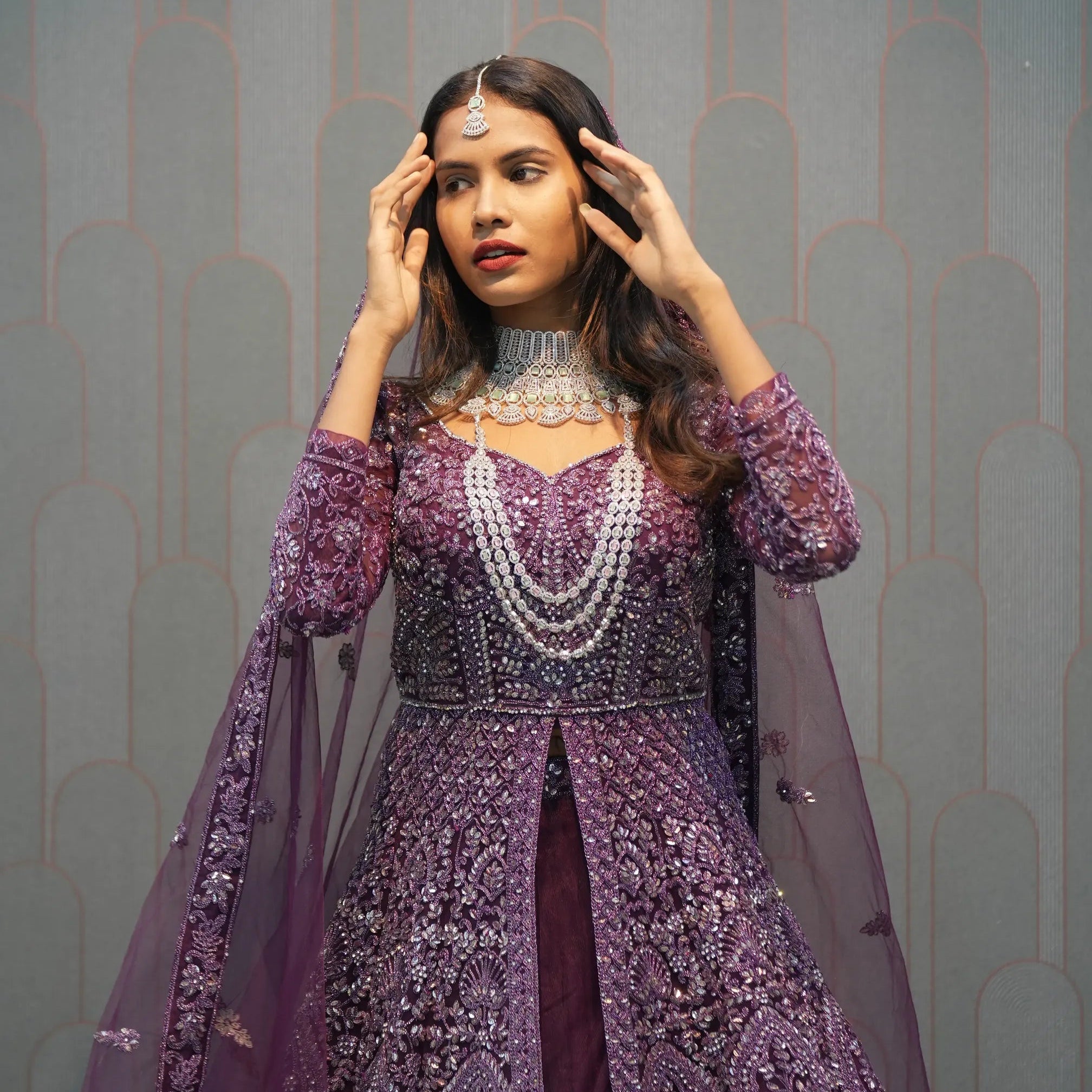 Woman in a purple embroidered outfit with 'POSH' branding in the background