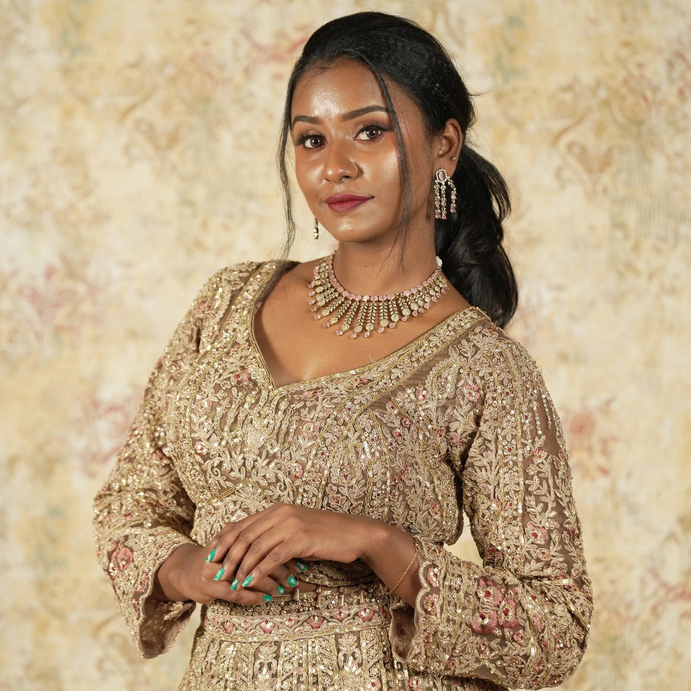 Woman wearing a patterned dress with jewelry against a floral background