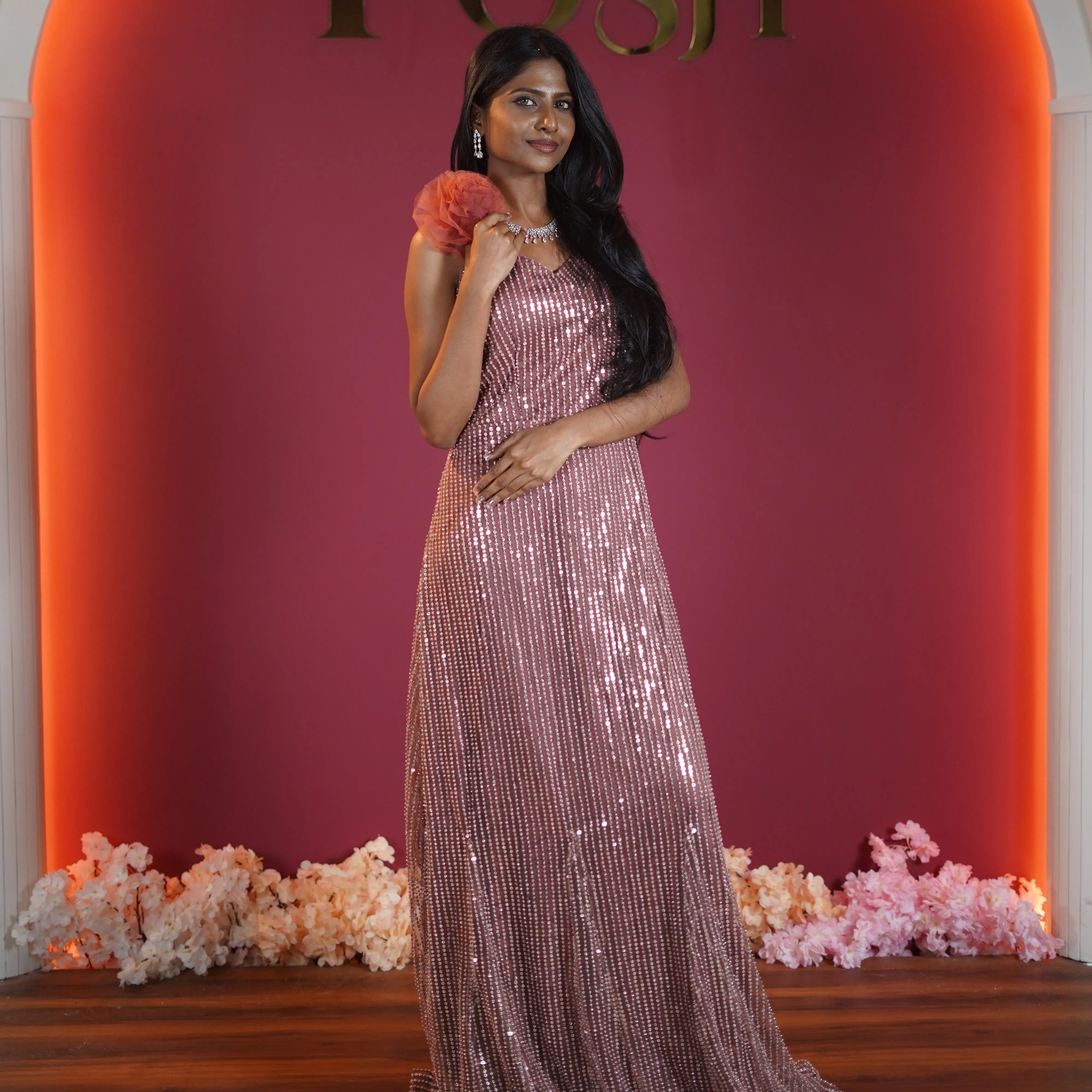 rose gold sequin evening gown with floral shoulder detail available at Posh Wedding Rental Kerala gown rental
