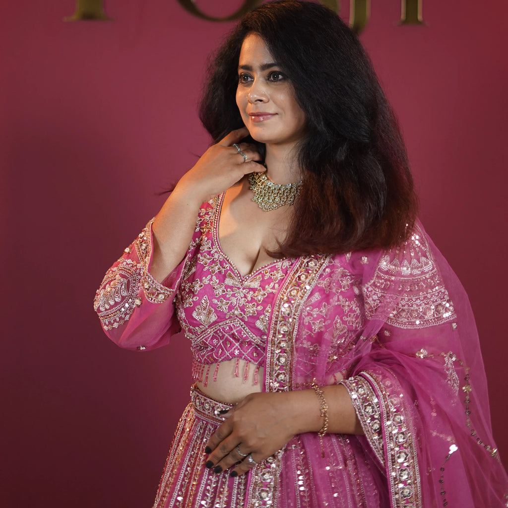 Pink designer bridal lehenga with heavy gold embroidery available on rent at Posh Wedding Rentals Kerala.