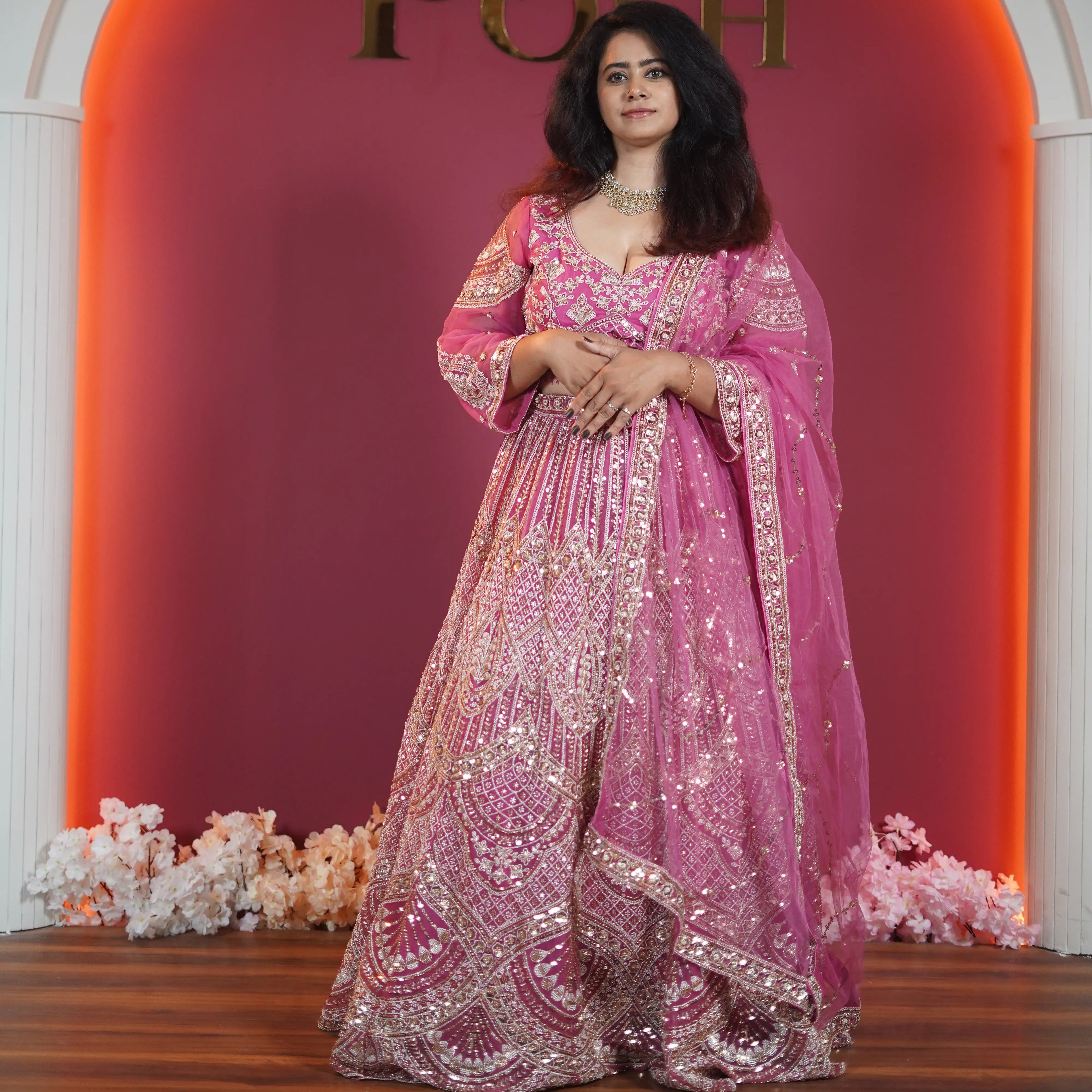 Pink designer bridal lehenga with heavy gold embroidery available on rent at Posh Wedding Rentals Kerala.