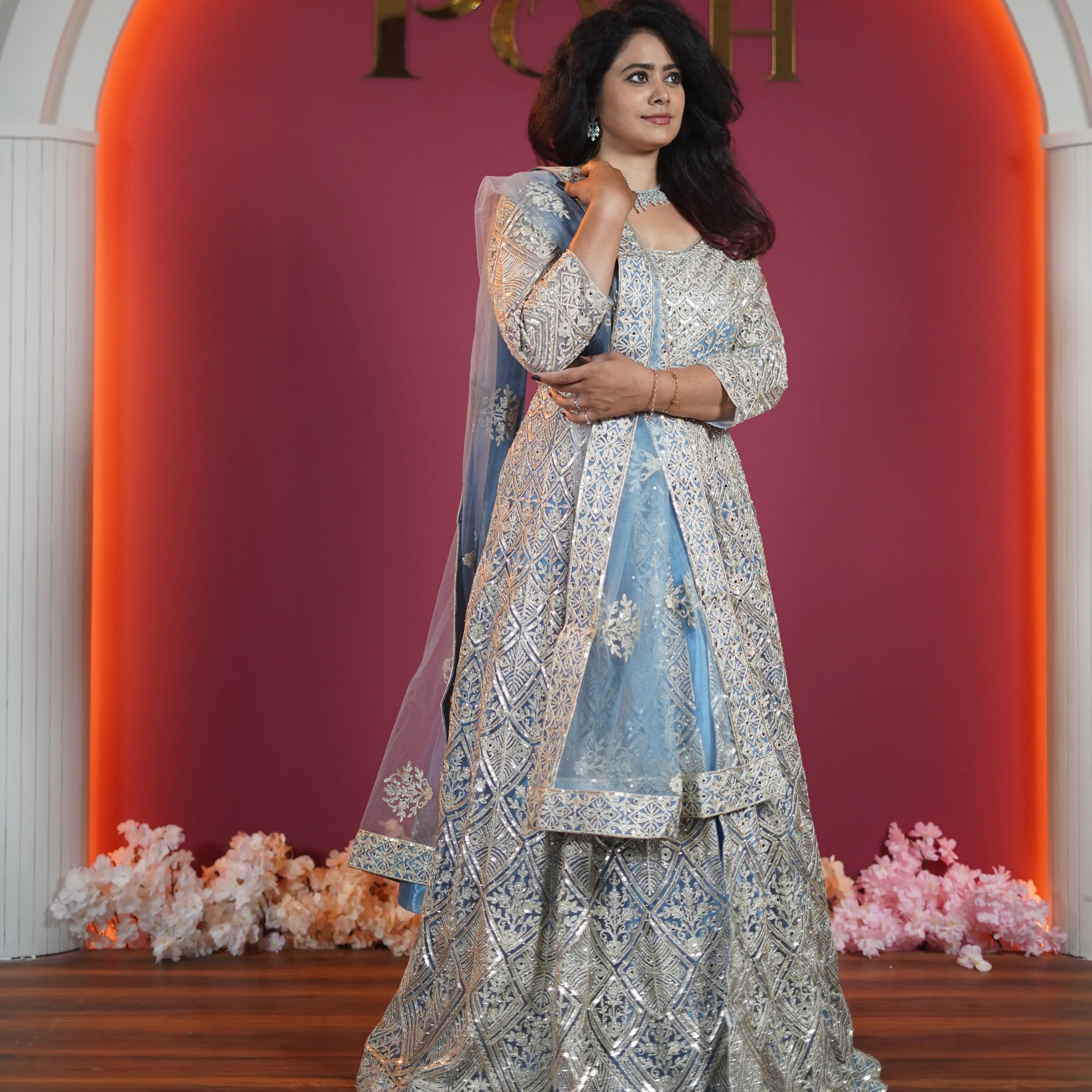 Elegant bride in pastel blue designer Anarkali with heavy silver embroidery from Posh Wedding Rentals premium collection.
