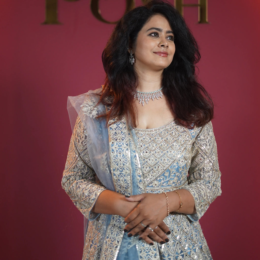 Elegant bride in pastel blue designer Anarkali with heavy silver embroidery from Posh Wedding Rentals premium collection.